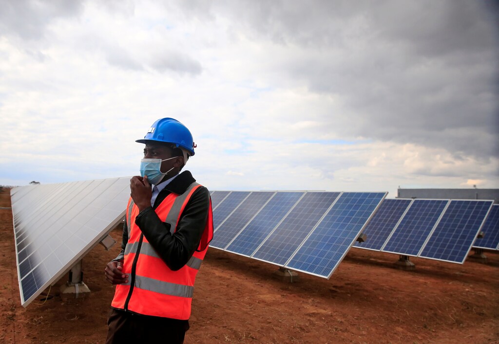 A worker walks past solar panels at Centragrid power plant in Nyabira, Zimbabwe, June 22, 2020