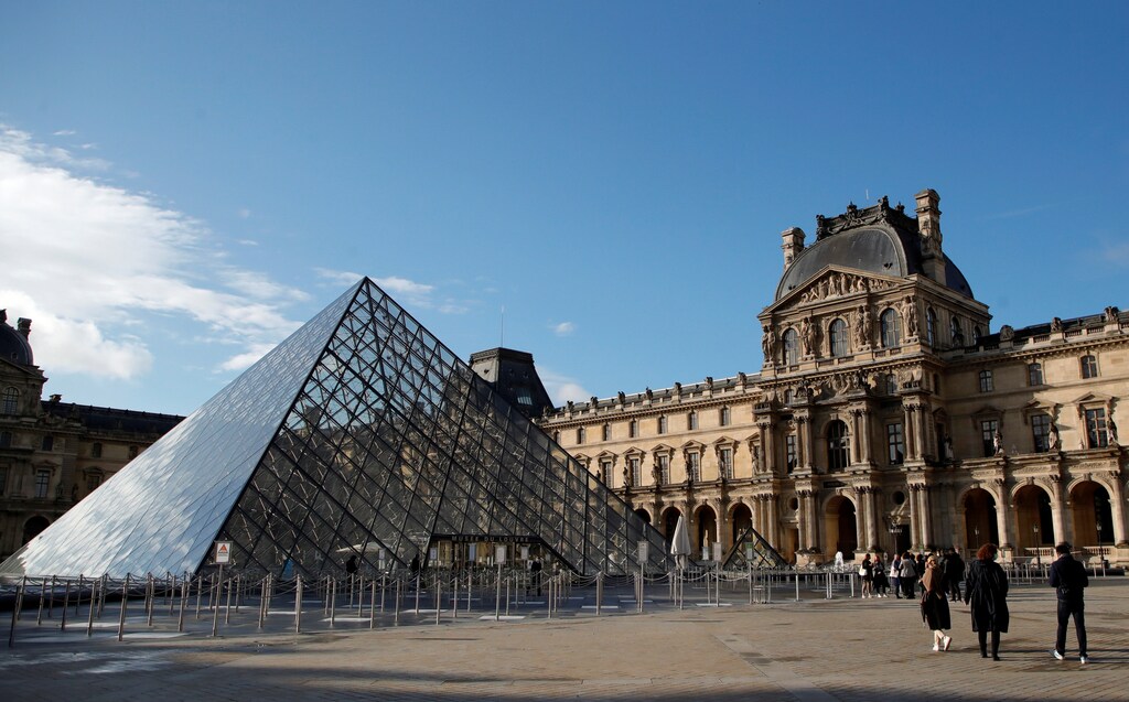 Journalists stand in front of the Louvre Pyramid designed by Chinese-born U.S. architect Ieoh Ming Pei in Paris as the Louvre museum reopens its doors to the public after more than 6 months of closure due to the coronavirus disease (COVID-19) outbreak in France, May 19, 2021. REUTERS/Sarah Meyssonnier