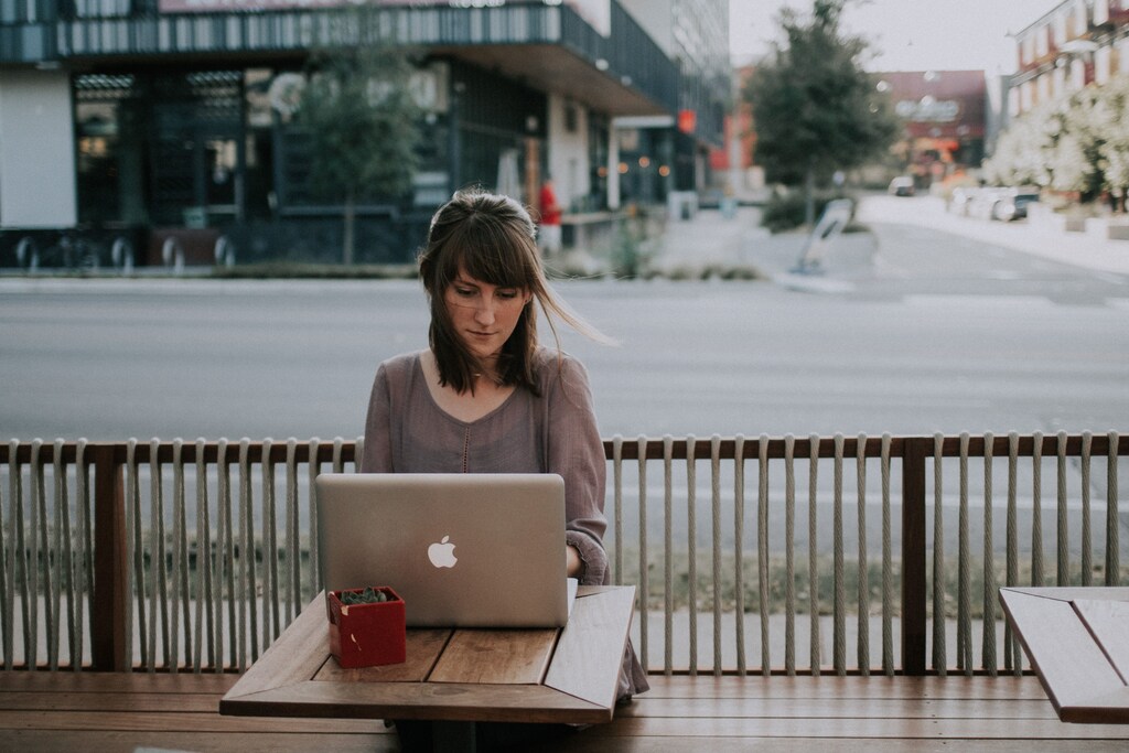 A lady working on her laptop outside, illustrating that the future of work is flexible