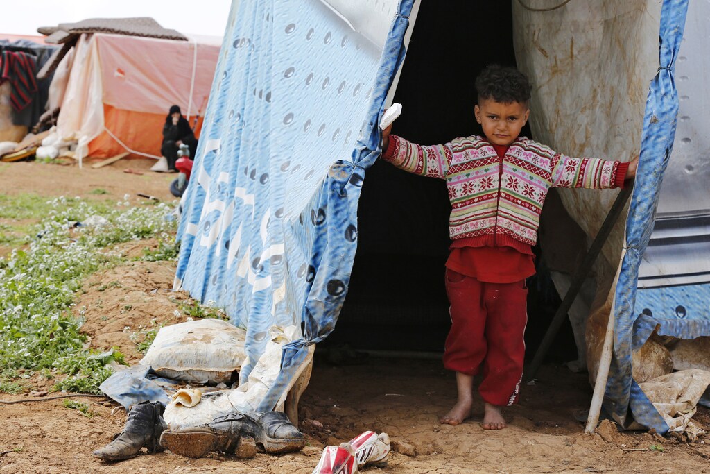 A Syrian refugee boy from Idlib, who now lives in Jordan after his family fled the violence in Syria, stands in front of his family's tent at a tented settlement in Madaba city, near Amman March 13, 2015. March 15 marks the fourth anniversary of peaceful protests against Syrian President Bashar al-Assad that started of the devastating conflict. After a government crackdown, the war has expanded into a civil conflict with regional backers. The conflict has killed some 200,000 people, created more than 3.9 million refugees, mostly in Turkey, Lebanon and Jordan, and displaced 7.6 million people within Syria, U.N. figures show. Picture taken March 13, 2015. REUTERS/Muhammad Hamed (JORDAN - Tags: POLITICS CONFLICT CIVIL UNREST SOCIETY IMMIGRATION) - GM1EB3F1RD501