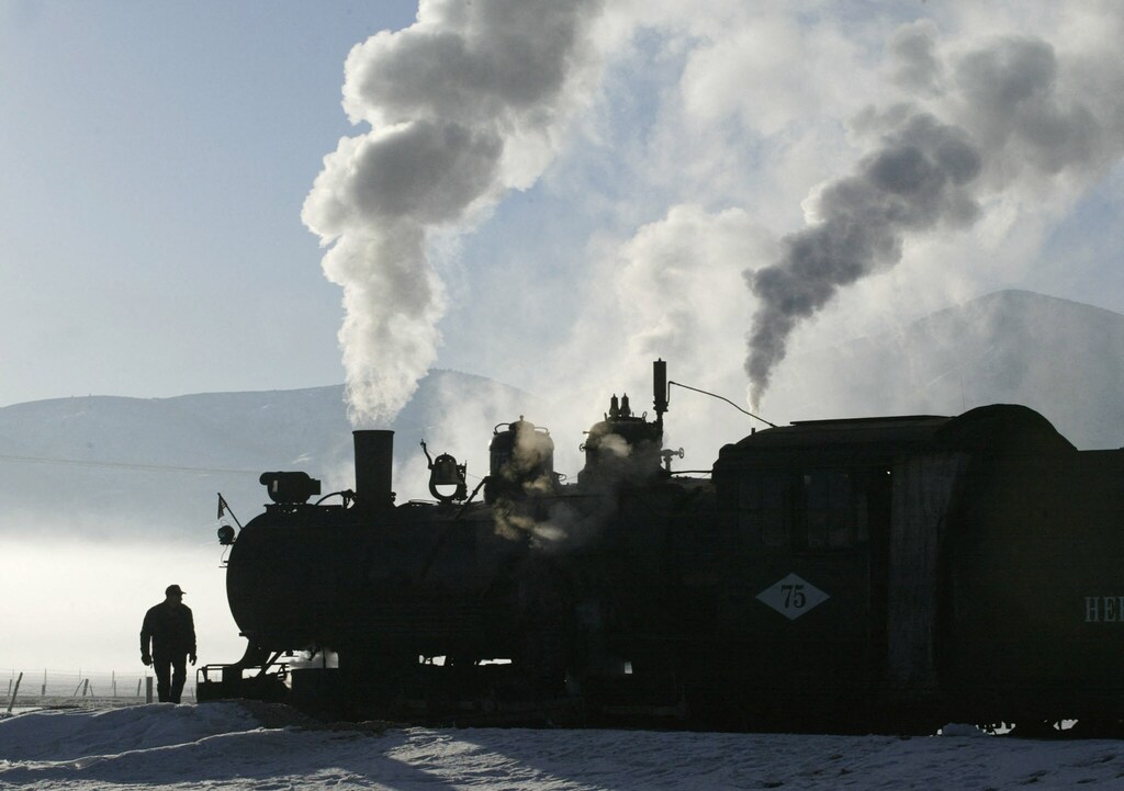 An engineer walks around the steam engine that takes spectators to see thecross country events in Soldier Hollow during the Salt Lake 2002 OlympicWinter Games, early February 15, 2002. The Games run through February 24. REUTERS/Kevin LamarqueRR