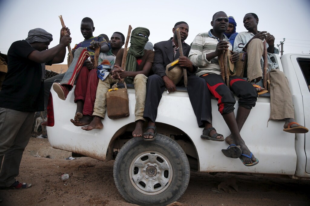 Migrants sit in the back of a truck at a local immigration transit centre in the desert town of Agadez, Niger May 25, 2015. African migrants in overcrowded pickup trucks, encouraged by social media messages from friends who survived the perilous journey across the Mediterranean, set off from Agadez, an ancient trading town on the edge of the Sahara, to cross Niger in the uncertain journey towards Europe via Libya, where the collapse of the government has offered an open door for smugglers. Mostly young men, escaping grinding poverty in neighbouring Benin or Burkina Faso, face bandits and often have to pay bribes en route, on top of the hefty payments to people smugglers. International focus on the issue of migration into Europe has sharpened after hundreds of migrants drowned while trying to cross the sea from North Africa in overcrowded and unsafe vessels. REUTERS/Akintunde Akinleye TPX IMAGES OF THE DAY PICTURE 34 OF 36 FOR WIDER IMAGE STORY SMUGGLED THROUGH NIGERSEARCH SAHARA AKINLEYE FOR ALL IMAGES TPX IMAGES OF THE DAY - RTX1EXBV