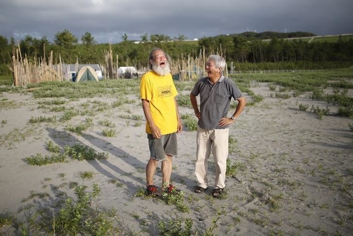 70-year-old Yoshiharu Ogawa (R) exchanges smiles with 66-year-old Mitsuro Sudo in front of their protesters' campsite on the sandy beach near Kyushu Electric Power's Sendai nuclear power station in Satsumasendai, Kagoshima prefecture, Japan, July 8, 2015. Japan is due to switch on a nuclear reactor for the first time in nearly two years as Prime Minister Shinzo Abe seeks to reassure a nervous public that tougher standards mean the sector is now safe after the Fukushima disaster in 2011. The head of Japan's atomic watchdog has said that the new safety regime meant a repeat of the Fukushima disaster would not happen, but protesters outside the Sendai plant are not convinced. REUTERS/Issei Kato TPX IMAGES OF THE DAYPICTURE 5 OF 30 FOR WIDER IMAGE STORY "PROTESTING JAPAN'S NUCLEAR RESTART".SEARCH "KATO SENDAI" FOR ALL PICTURES. TPX IMAGES OF THE DAY