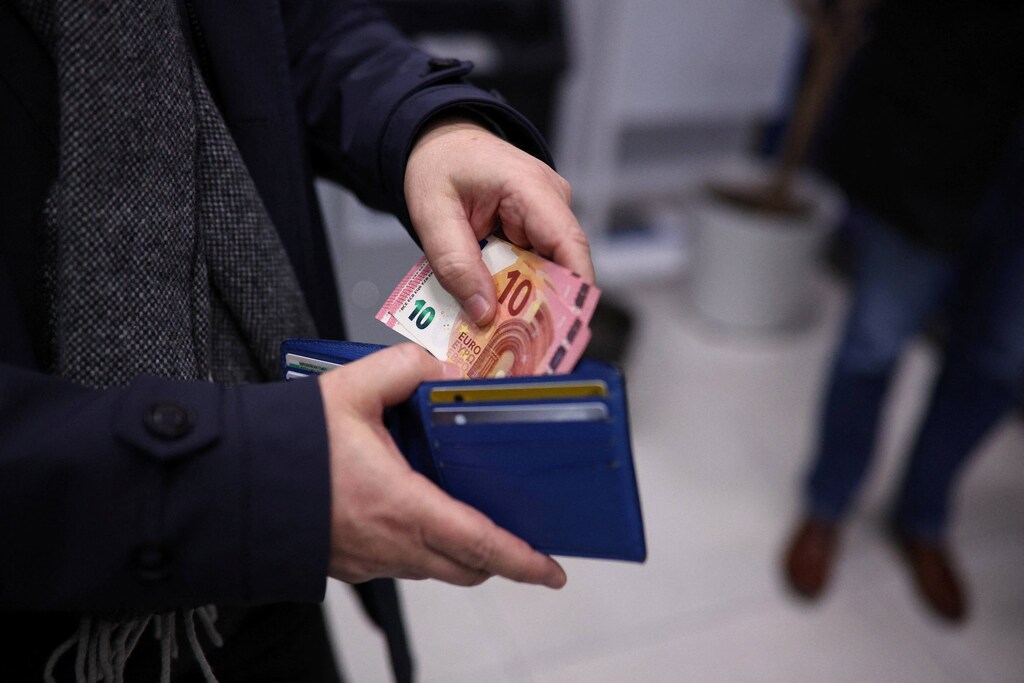 Un hombre muestra billetes de euro tras retirarlos de un cajero automático en una sucursal del banco UBB en Sofía, Bulgaria, el 1 de enero de 2026, cuando Bulgaria se incorpora a la eurozona. REUTERS/Spasiyana Sergieva