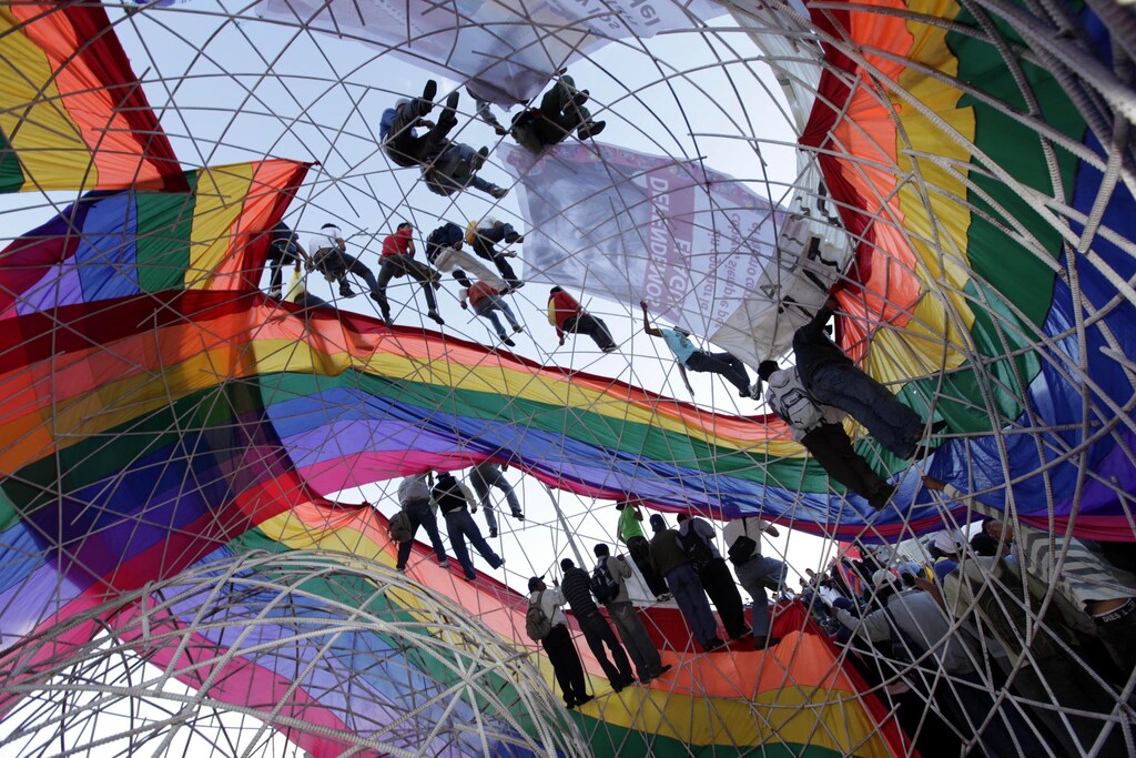 Ecuadorean Indian demonstrators are seen on a globe-shaped structure during a speech by their leaders in a park in Quito May 13, 2010. Ecuadorean lawmakers on Thursday failed to reach a deal on suspending debate of a contested water bill that has sparked protests by indigenous groups who fear it threatens their rights to natural resources. REUTERS/Guillermo Granja (ECUADOR - Tags: POLITICS CIVIL UNREST) - RTR2DUNV