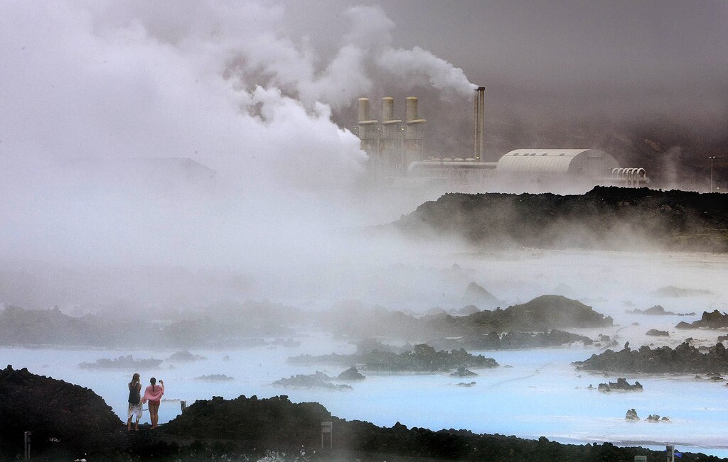 Visitors take pictures of the Svartsengi geothermal power plant near the Blue Lagoon hot springs outside the town of Grindavik May 12, 2008. REUTERS/Bob Strong (ICELAND) - GM1E45D084001