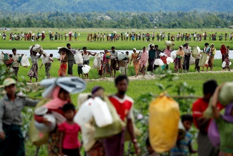 Rohingya refugees, who crossed the border from Myanmar two days before, walk after they received permission from the Bangladeshi army to continue on to the refugee camps, in Palang Khali, near Cox's Bazar, Bangladesh October 19, 2017. Reuters photographer Jorge Silva: "This picture was taken after a huge group of people crossed into Bangladesh and then had to wait three days and nights for the Bangladeshi Army's permission to continue walking into the makeshift camps. The line of people seemed endless. Long hours moving slowly across the embankments of the rice field. Mothers with babies and pregnant women, elderly people with illnesses, men carrying their entire life on their shoulders. They were safe from violence, but the challenge of surviving was still waiting for them on this side of the river." REUTERS/Jorge Silva/File Photo SEARCH "POY ROHINGYA" FOR THIS STORY. SEARCH "REUTERS POY" FOR ALL BEST OF 2017 PACKAGES. TPX IMAGES OF THE DAY. - RC1DF361B970