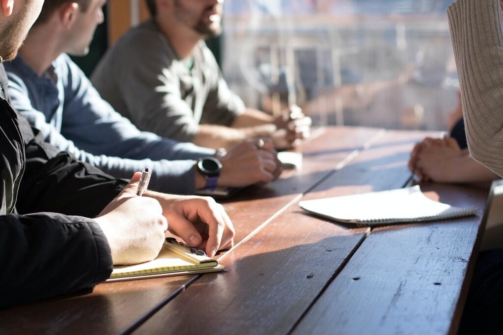 Three people sitting at a table having a discussion.
