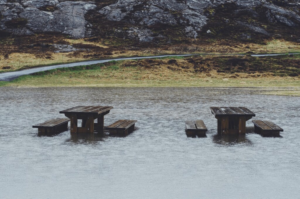 Benches and tables partly submerged by a flood.