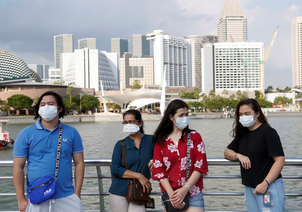 Tourists wear protective face masks at the Merlion Park in Singapore, January 28, 2020. REUTERS/Feline Lim - RC20PE9Y73XW