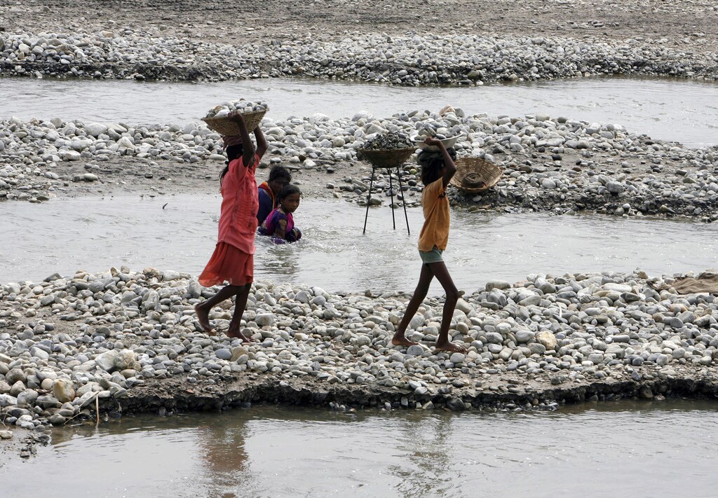 Child labourers carry baskets of stones on the banks of river Balason on the outskirts of the eastern Indian city of Siliguri June 12, 2009. The International Labour Organization (ILO) celebrates World Day Against Child Labour on Friday.