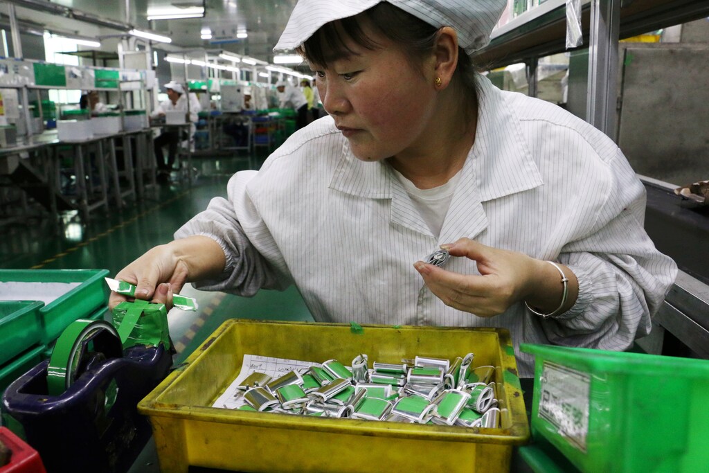 image of an employee working at a production line of lithium ion batteries inside a factory in Dongguan, Guangdong province, China