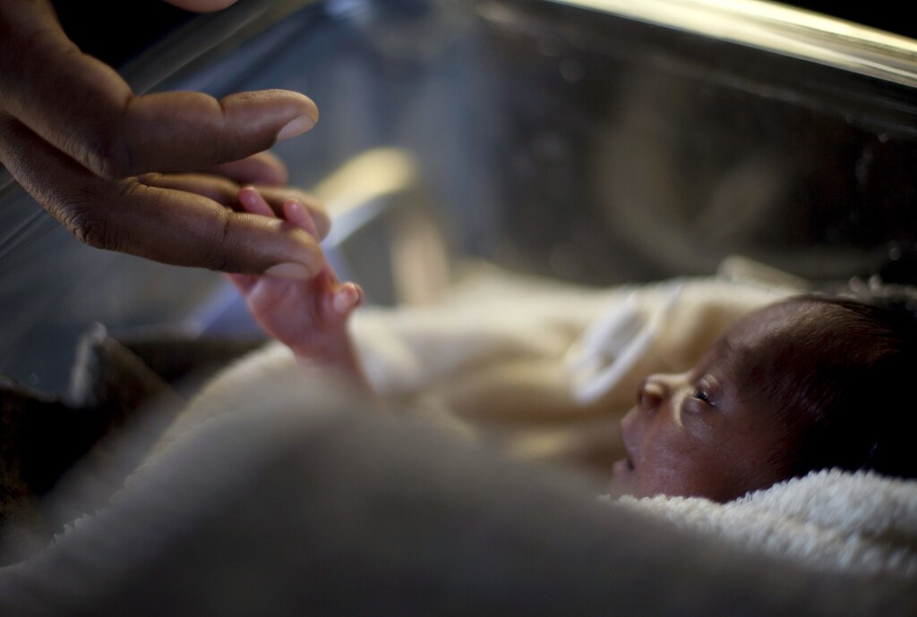 A man touches his baby, who was born three days ago, at the Israeli hospital in Port-au-Prince January 20, 2010. Foreign governments and aid agencies have flown in medics from around the worldto help earthquake survivors but they were only able to get to work in the past couple of days. REUTERS/Carlos Garcia Rawlins