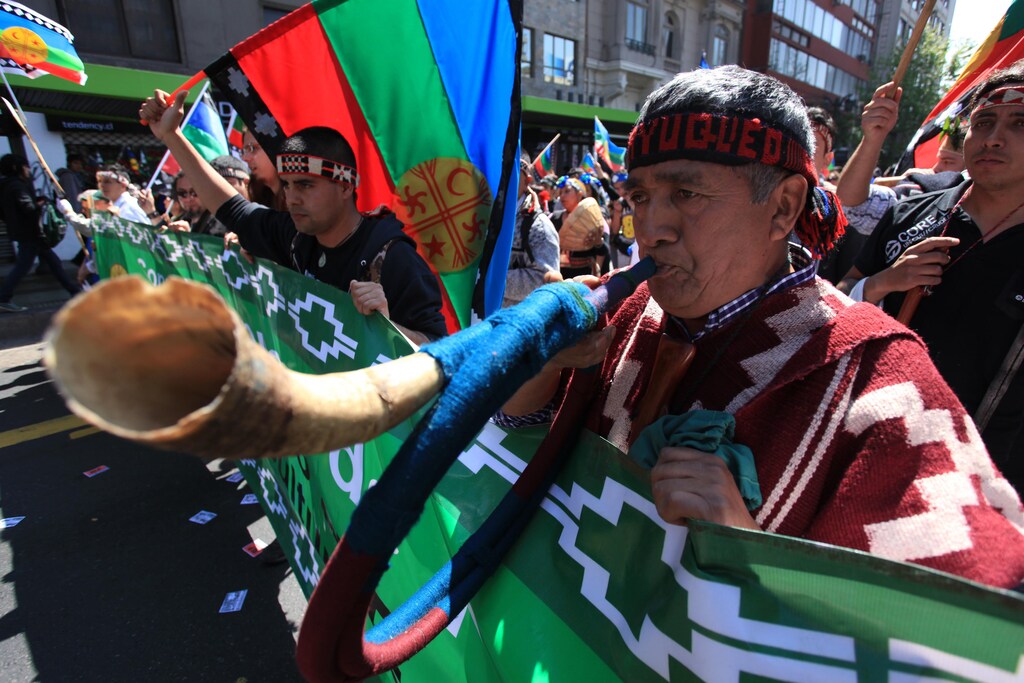 An indigenous Mapuche blows a Trutruca, a musical instrument, during a rally through downtown Santiago October 15, 2012. This year marks the 520th anniversary of Christopher Columbus' arrival to the Americas. Most indigenous people in Latin America consider it the day Columbus brought slavery, disease, colonisation and genocide from Europe to the Americas, according to them. REUTERS/Cristobal Saavedra (CHILE - Tags: POLITICS SOCIETY CIVIL UNREST) - GM1E8AG08F501