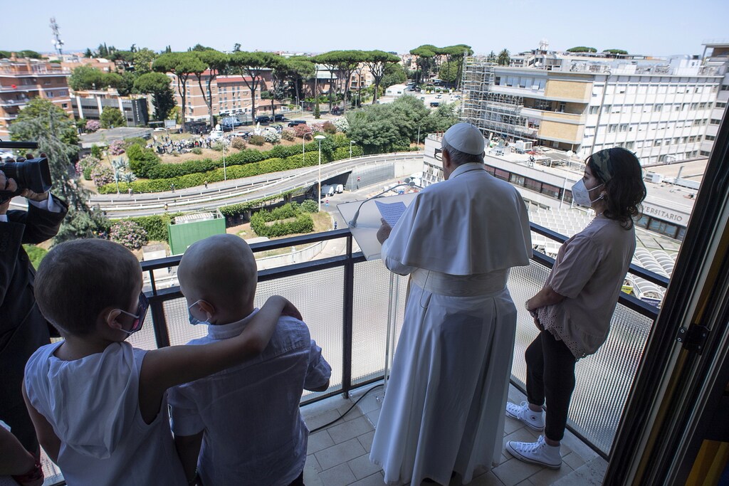 Children accompany Pope Francis as he leads the Angelus prayer from a balcony of the Gemelli hospital, as he recovers following scheduled surgery on his colon, in Rome, Italy