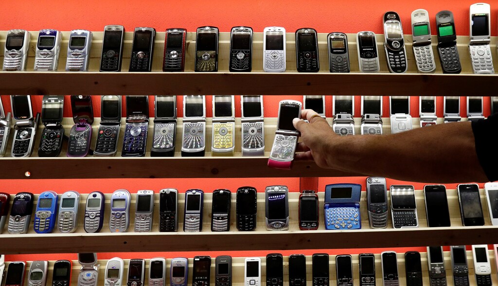 A man grabs an old mobile phone inside of a private museum of phones in Dobsina, Slovakia, September 6, 2017. Picture taken September 6, 2017. REUTERS/David W Cerny