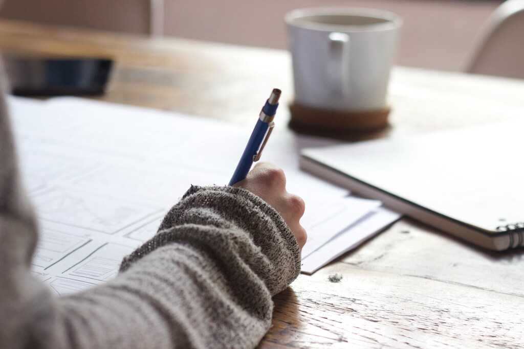 a person sits at a desk filling out worksheets