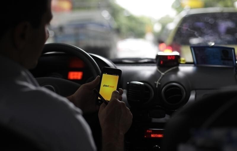 A taxi driver checks an app on his smartphone in Rio de Janeiro April 15, 2013. Picture taken on April 15, 2013.