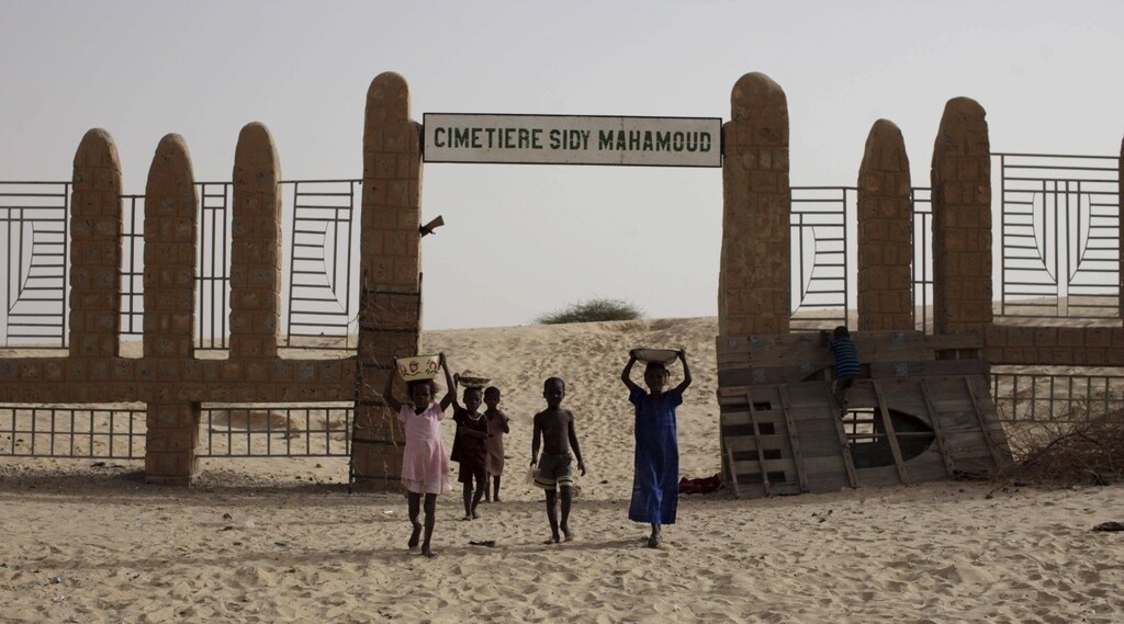 Children walk in front of the Sidy Mahamoud cemetery, where Islamist militants destroyed ancient mausoleums in Timbuktu, Mali, July 25, 2013.