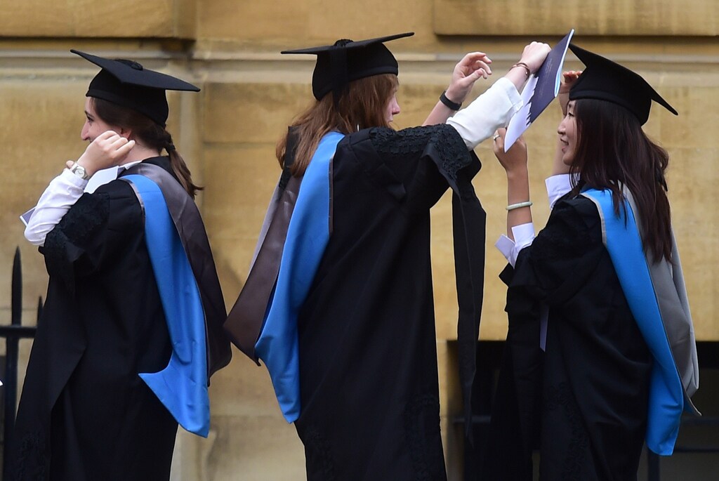 Graduates gather outside the Sheldonian Theatre after a graduation ceremony at Oxford University, in Oxford, Britain July 15, 2017. REUTERS/Hannah McKay - RTX3BKM2