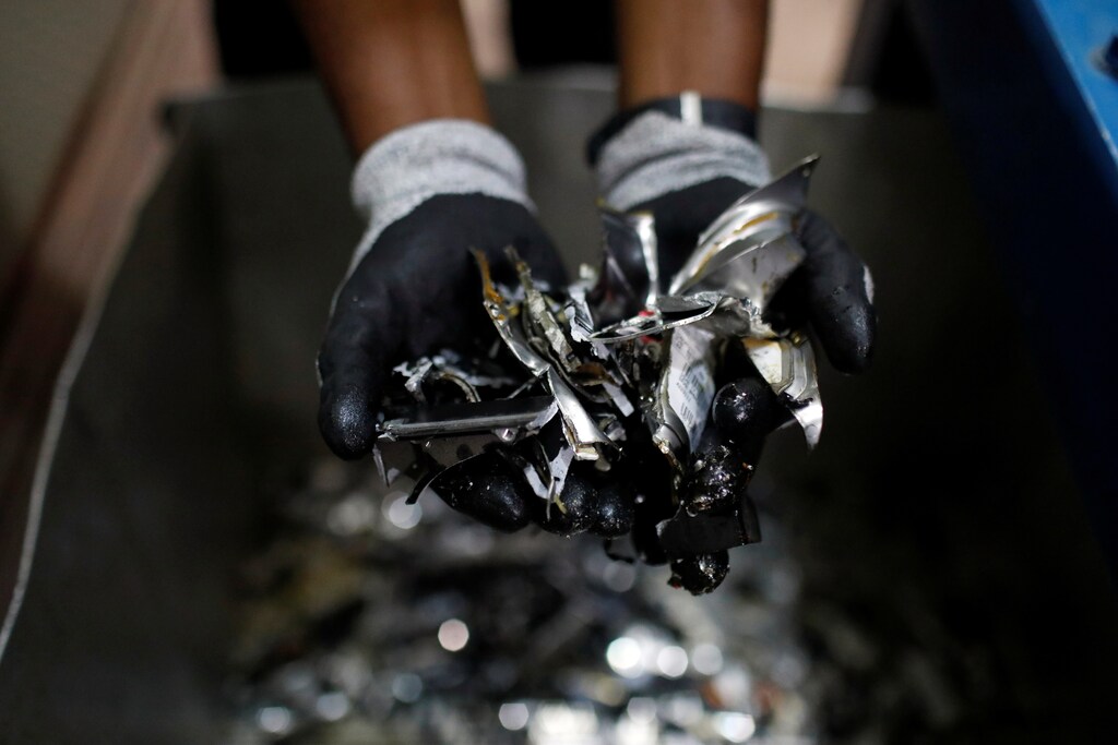 Un empleado muestra un puñado de discos duros triturados para procesamiento en la planta de recuperación y reciclaje E-Terra Matter en Festac, Lagos, Nigeria.