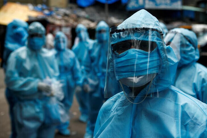 Healthcare workers wait to take off their personal protective equipment (PPE) after the end of a check-up camp for the coronavirus disease (COVID-19) at a slum in Mumbai, India June 14, 2020. REUTERS/Francis Mascarenhas