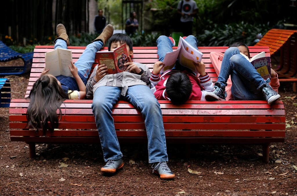 Children read books on a bench at the Audiorama section with classical music playing from speakers within the trees at Chapultepec Park in Mexico City, Mexico November 19, 2017. REUTERS/Tim Chong - RC1AAF07BDA0