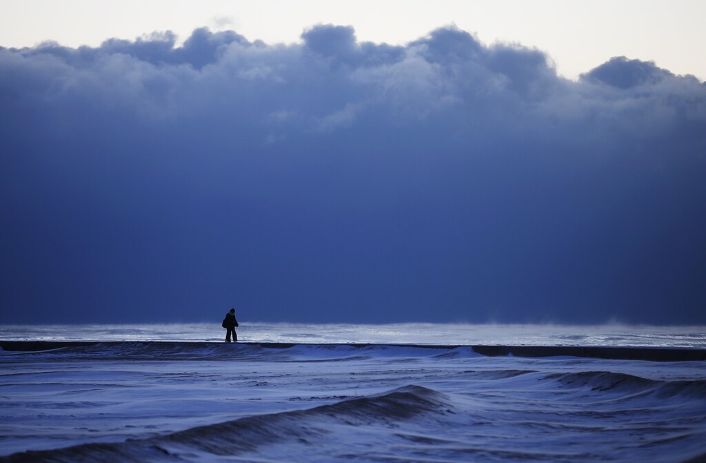 A woman walks along a frozen beach at Lake Michigan in Chicago, Illinois, January 7, 2015. REUTERS/Jim Young (UNITED STATES - Tags: ENVIRONMENT SOCIETY TPX IMAGES OF THE DAY) - GM1EB1802SQ01