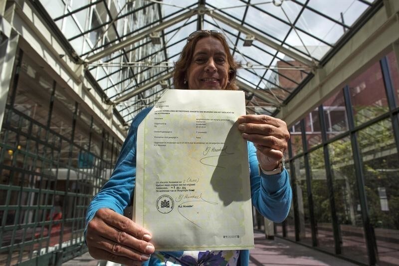 Petra van Dijk, 51, displays her new documents after changing her officially registered gender from male to female, in the City Hall in Amsterdam July 1, 2014. Dijk is among the first to obtain new documents on Tuesday, when a new law came into effect, legalising the registration of a transgender person's preferred gender in official state documents, including identity cards and passports. It eliminates the previous law, which required hormonal treatment, surgery or sterilization before any change in gender registration is allowed.