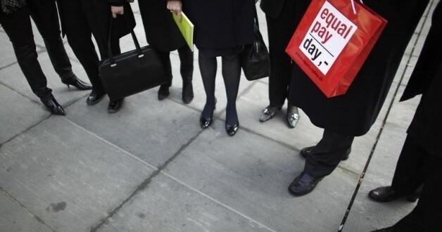Swiss Economy Minister Johann Schneider-Ammann holds a bag with the writing 'equal pay day' as he speaks to members of the women's section of the Swiss Liberal Free Democratic Party (FDP) on International Women's Day, in Bern March 8, 2011.