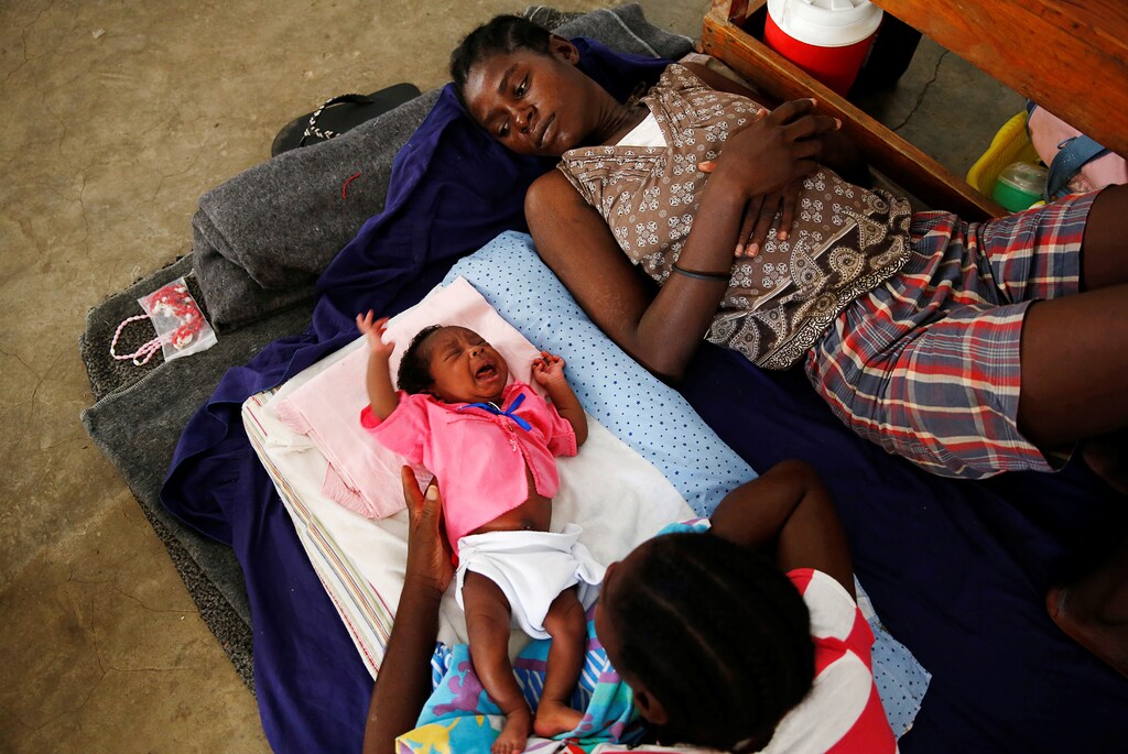 Women and a child rest at a shelter set up at a school after Hurricane Matthew passes in Jeremie, Haiti, October 8, 2016. REUTERS/Carlos Garcia Rawlins TPX IMAGES OF THE DAY - S1BEUFXQREAA