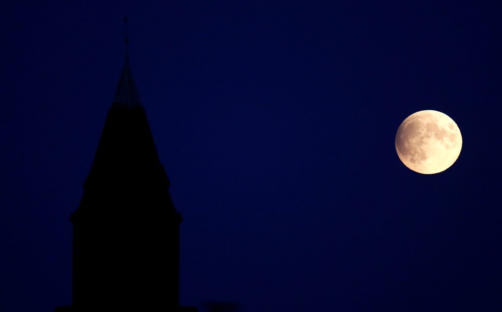 A tower of a building at Steglitz district is pictured beside a partial lunar eclipse in Berlin, Germany, July 16, 2019. REUTERS/Fabrizio Bensch - RC1AEA41E700