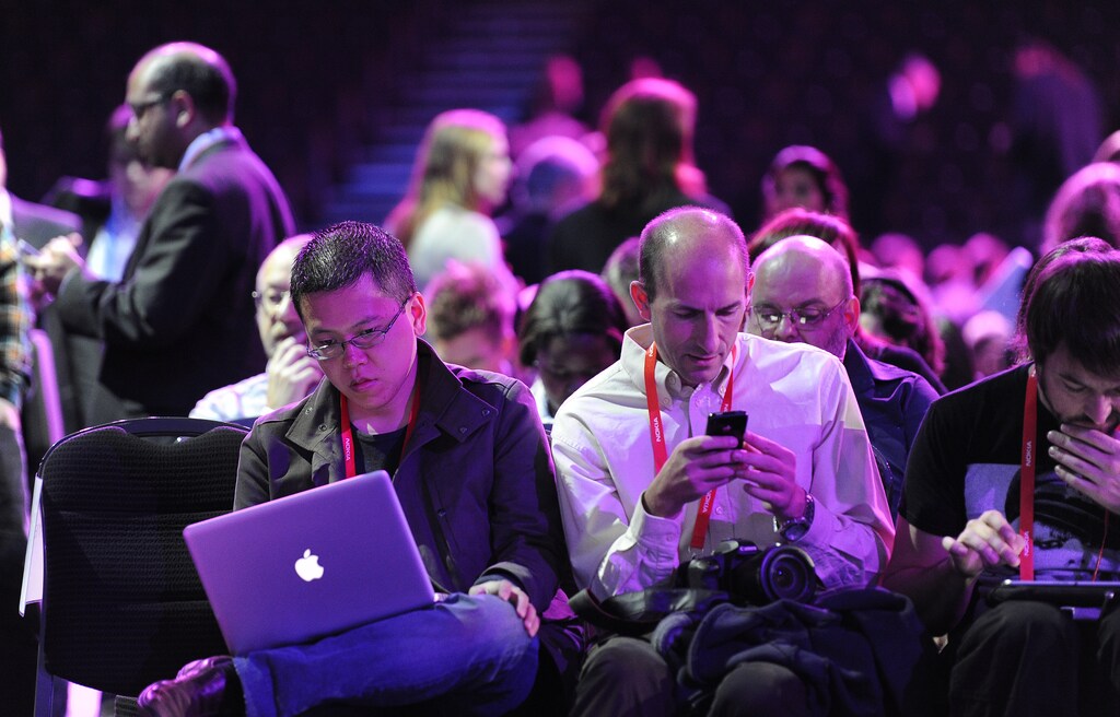 People attending the Nokia World event check their laptops and mobile devices in London October 26, 2011.