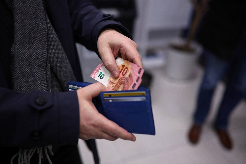 A man shows euro banknotes after withdrawing them from an ATM at a bank branch of UBB bank in Sofia, Bulgaria, January 1, 2026, as Bulgaria joins the Eurozone. REUTERS/Spasiyana Sergieva