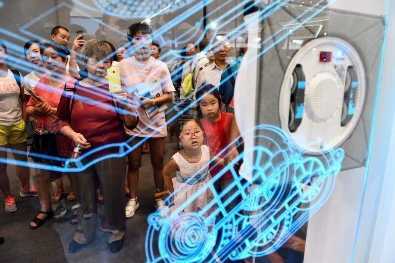 Visitors look at a window cleaning robot displayed at the first Smart China Expo in Chongqing, China August 23, 2018.