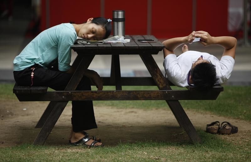 A woman sleeps at a bench at the end of a working day at the central business district of Singapore November 28, 2013.