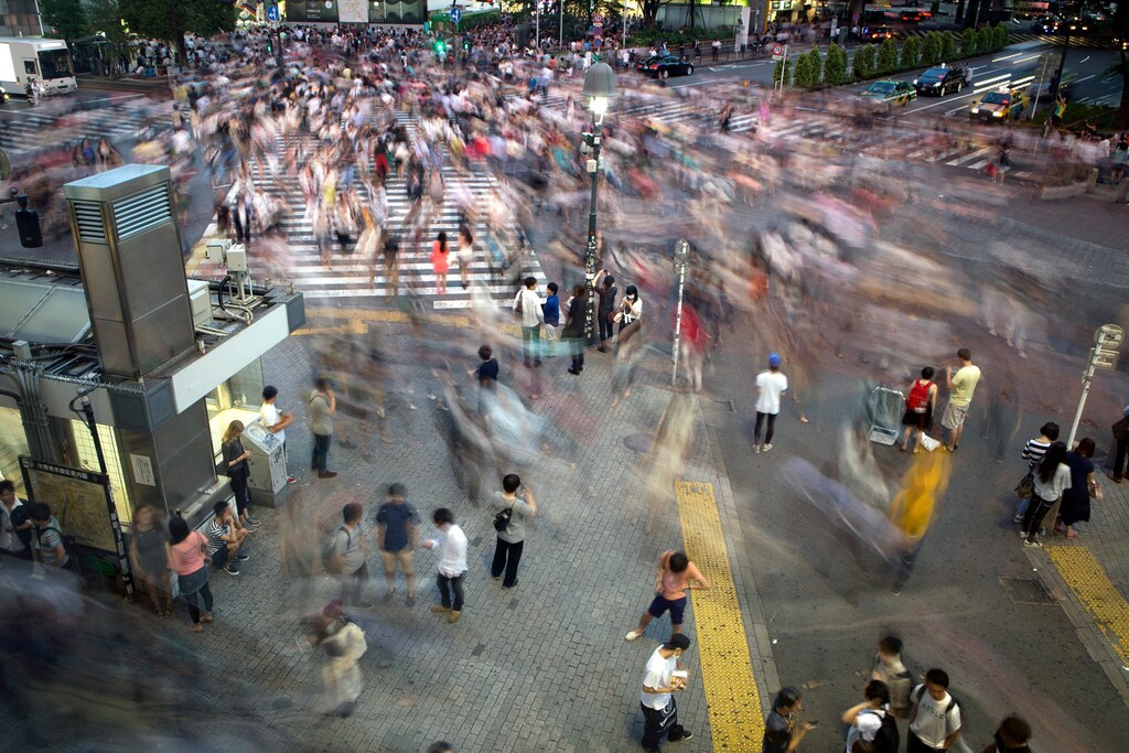 A busy urban crowd with motion-blurred pedestrians, illustrating the widespread impact of social and economic inequality