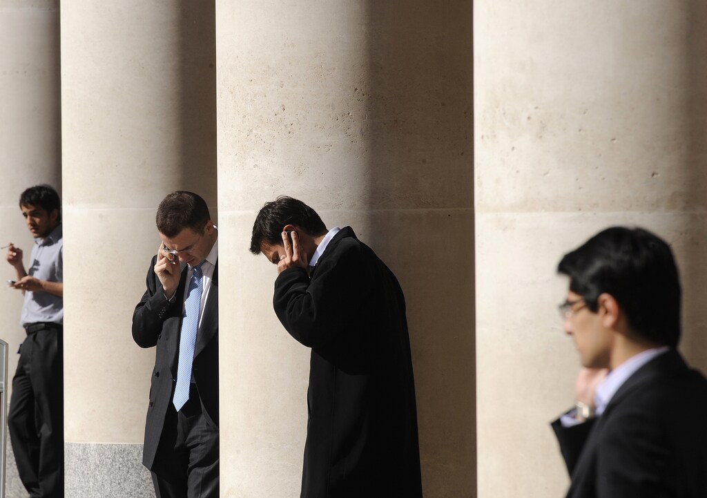 City workers make phone calls outside the London Stock Exchange in Paternoster Square in the City of London at lunchtime October 1, 2008. European policymakers have called on the U.S. Senate to approve a revised rescue plan aimed at tackling the worst financial crisis since the 1930s. REUTERS/Toby Melville (BRITAIN) - GM1E4A11PQ101