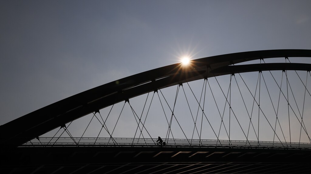 A cyclist crosses a bridge of the river Main early morning in Frankfurt, Germany March 9, 2016.