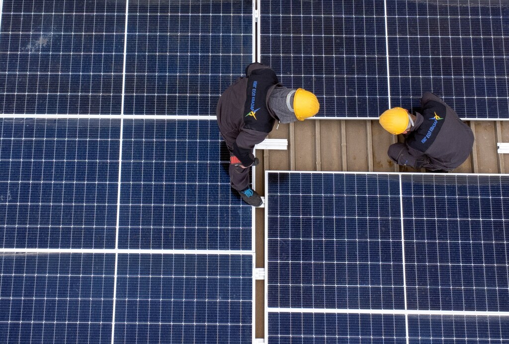 Workers install solar panels on an office building in Skopje, North Macedonia April 19, 2023. REUTERS/Ognen Teofilovski
