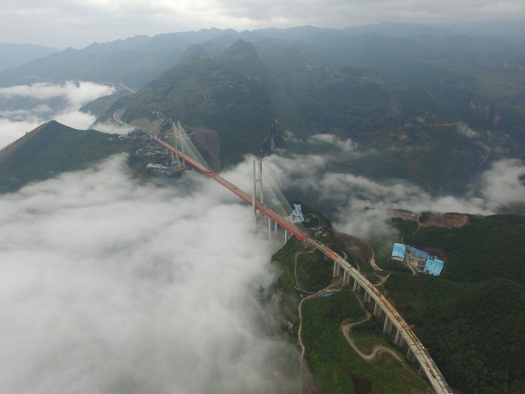 An aerial view of a bridge under construction that will connect two provinces in Bijie, Guizhou Province, China, September 10, 2016. Picture taken September 10, 2016. REUTERS/Stringer ATTENTION EDITORS - THIS IMAGE WAS PROVIDED BY A THIRD PARTY. EDITORIAL USE ONLY. CHINA OUT. NO COMMERCIAL OR EDITORIAL SALES IN CHINA. - RTSNANJ