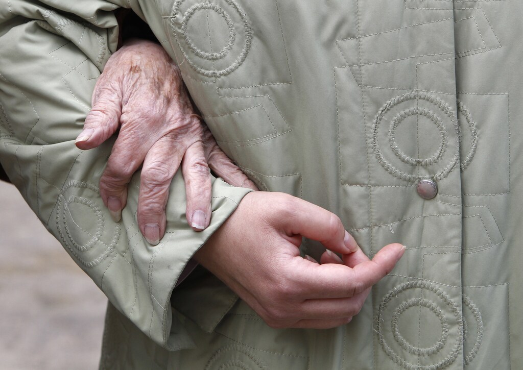 An elderly woman is escorted by an aide in London, March 22, 2010. REUTERS/Suzanne Plunkett (BRITAIN - Tags: SOCIETY HEALTH) - LM1E63M18ST01