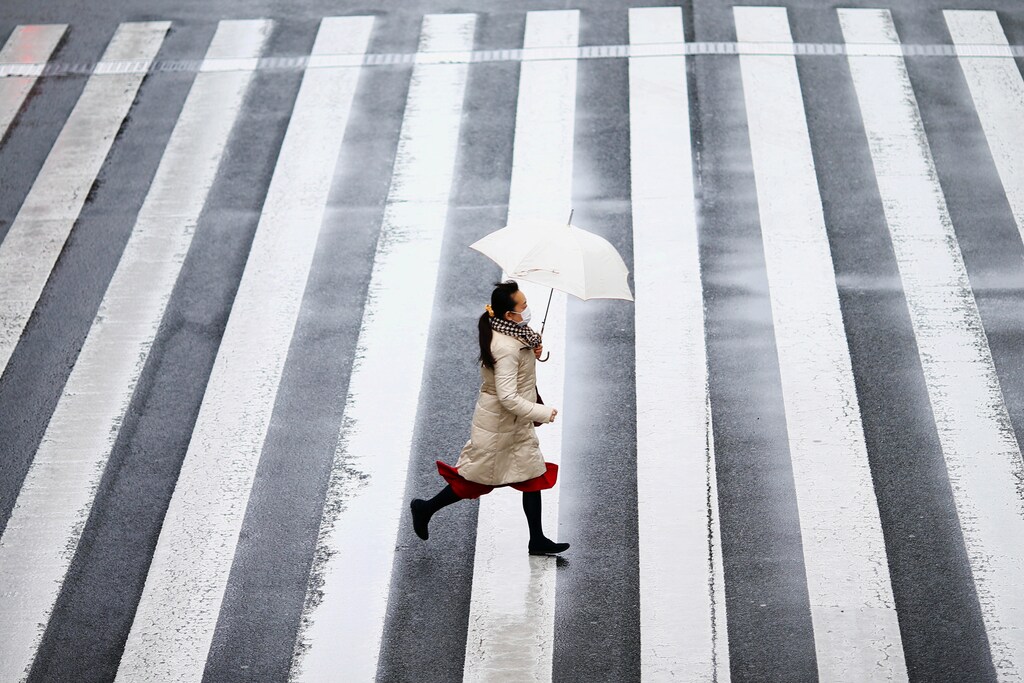 A woman wearing a protective face mask, following an outbreak of the coronavirus disease (COVID-19), runs on a street near Tamachi station in Tokyo, Japan March 8, 2020. REUTERS/Edgard Garrido - RC2OFF9NJ58S