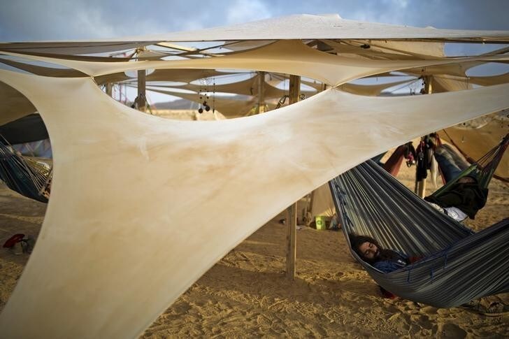A man sleeps during the Midburn festival at southern Israel May 22, 2015. The Israeli version of Nevada's Burning Man festival, concluded on Sunday in the country's southern Negev desert. In keeping with the Burning Man tradition, thousands of revellers set up camp in the desert for 5 days of art, dance and music, burning their exhibits on the last two nights of the festival. Picture taken May 22, 2015. REUTERS/Amir Cohen FOR EDITORIAL USE ONLY. NOT FOR SALE FOR MARKETING OR ADVERTISING CAMPAIGNS.