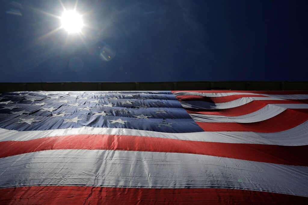 As 95-by-50-foot American flag is unfurled on the side of an apartment complex, a replica of the "The Great Flag" that was spun, woven, dyed, constructed and displayed on the same building by Amoskeag Manufacturing Company in 1914, in Manchester, New Hampshire, U.S., June 14, 2017. REUTERS/Brian Snyder - RC1F0DB46FD0