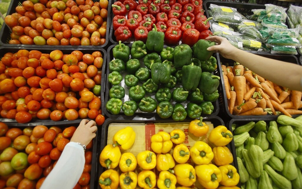 Customers select vegetables at a supermarket in Hanoi September 20, 2014. REUTERS/Kham (VIETNAM - Tags: FOOD BUSINESS) - RTR470M7