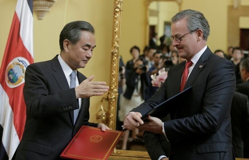 China's Foreign Minister Wang Yi (L) and Costa Rica's Foreign Minister Manuel Gonzalez exchange documents after signing a joint agreement at the foreign ministry in San Jose, Costa Rica September 15, 2017.