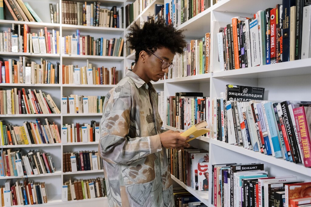 A young man browsing book shelves.