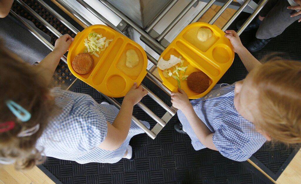 Students receive their lunch at Salusbury Primary School in northwest London June 11, 2014. This September, a new government scheme plans to give free meals to all reception, year 1 and 2 students registered in England's state-funded schools. Local media reports that this will amount to saving families about ?400 a year per child. REUTERS/Suzanne Plunkett (BRITAIN - Tags: EDUCATION SOCIETY FOOD) - GM1EA6B1O7X01