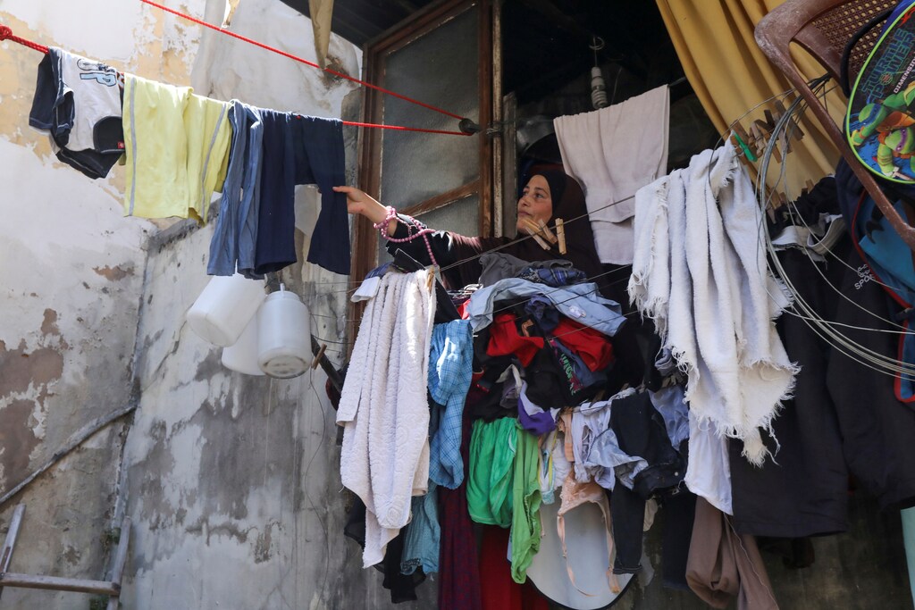 Sultana, wife of Amer al-Dahn, removes dry clothes at home in Tripoli, northern Lebanon July 1, 2020. Picture taken July 1, 2020. REUTERS/Mohamed Azakir - RC2RLH9RY6YQ